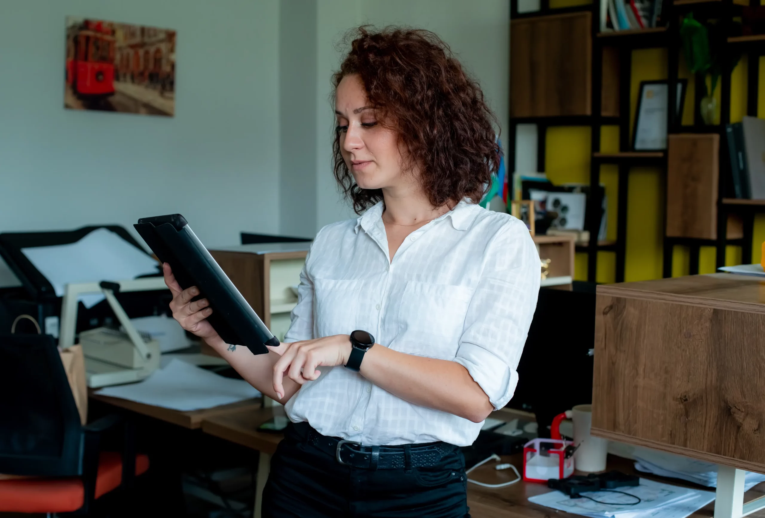 Mujer de negocios usando una tablet digital en una oficina moderna.